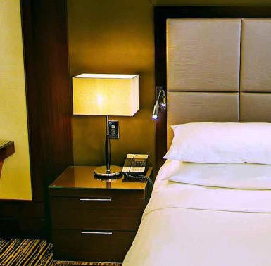Nightstand with reading lamp beside the bed